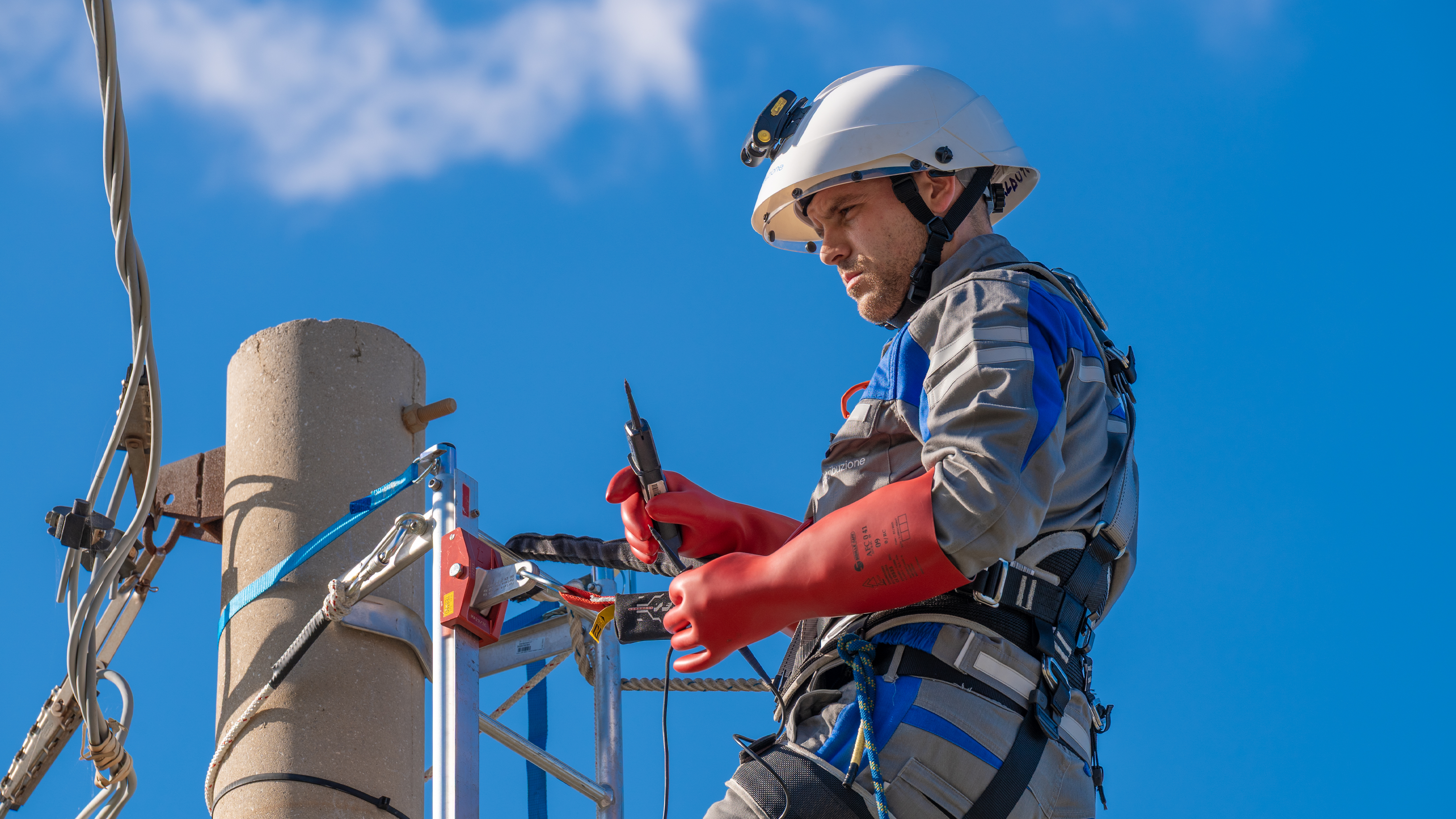 Immagine di un operaia e-distribuzione in divisa intenta nel loro lavoro