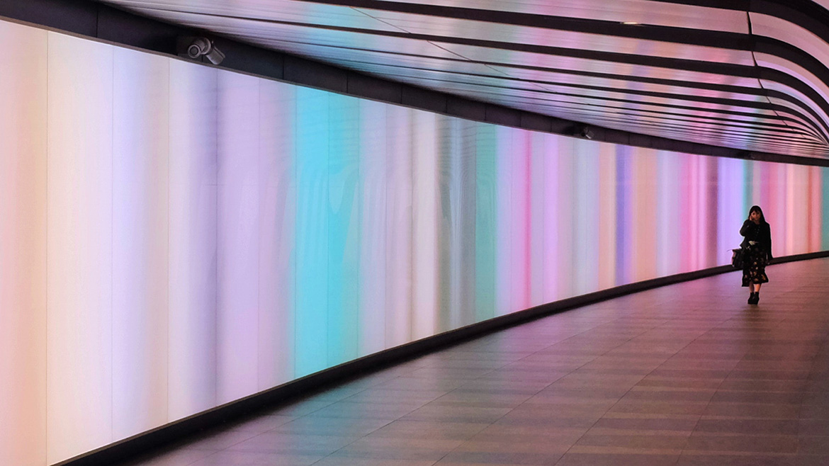 Immagine di un corridoio colorato con una donna in fondo
