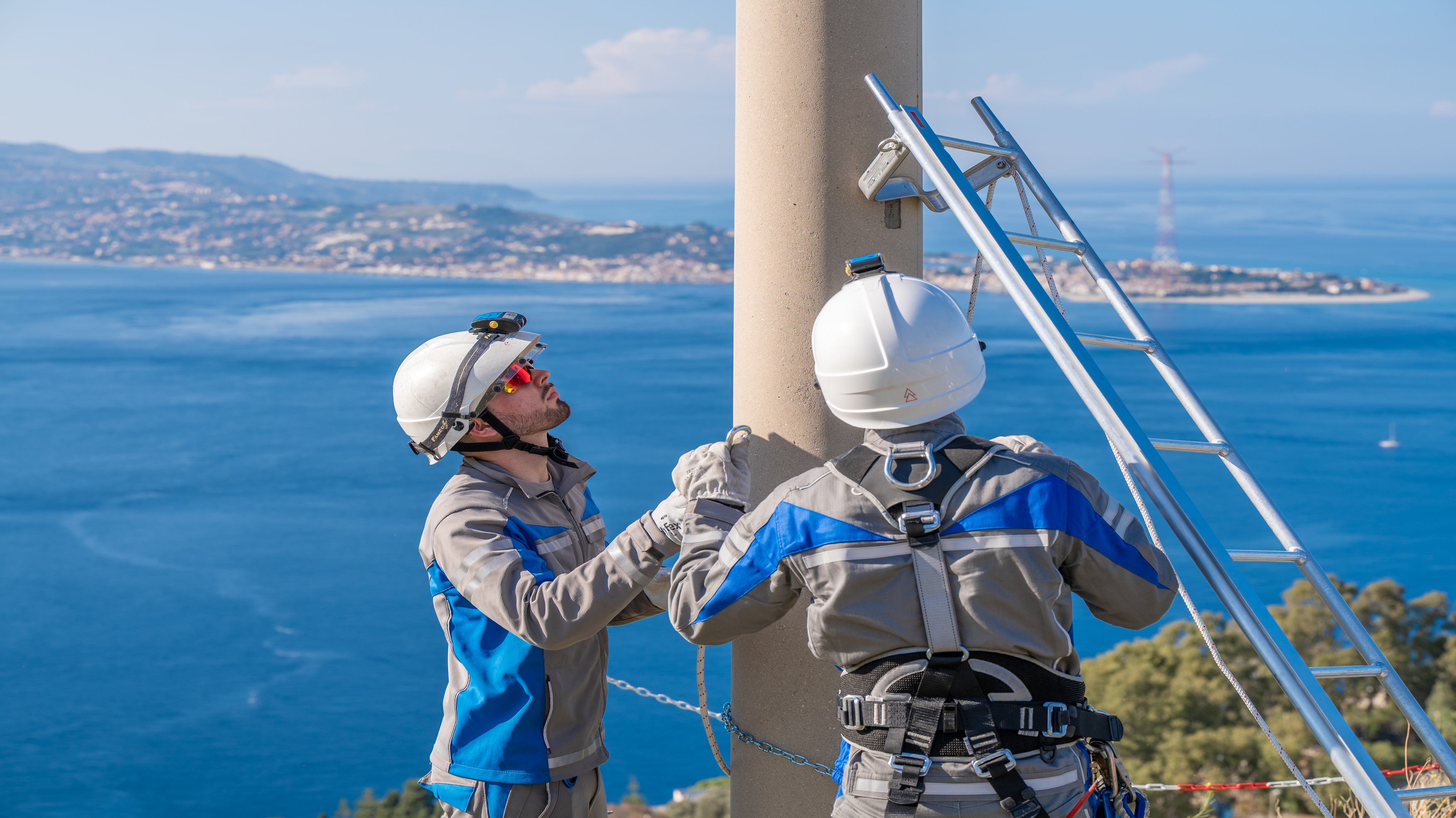 Foto di un operaio di E-Distribuzione su un palo
