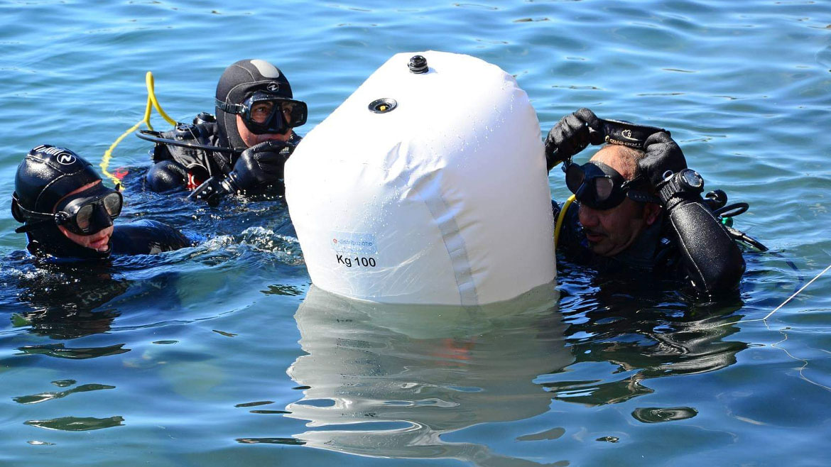 Foto di tre sub in procinto di immergersi con un pallone di e-distribuzione