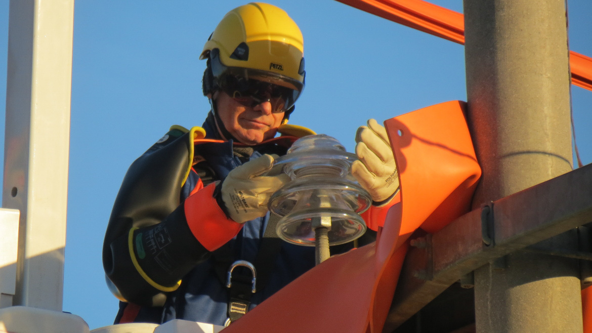 Tecnico di e-distribuzionei che lavora con la nuova metodologia "a contatto" direttamente sui conduttori a tensione