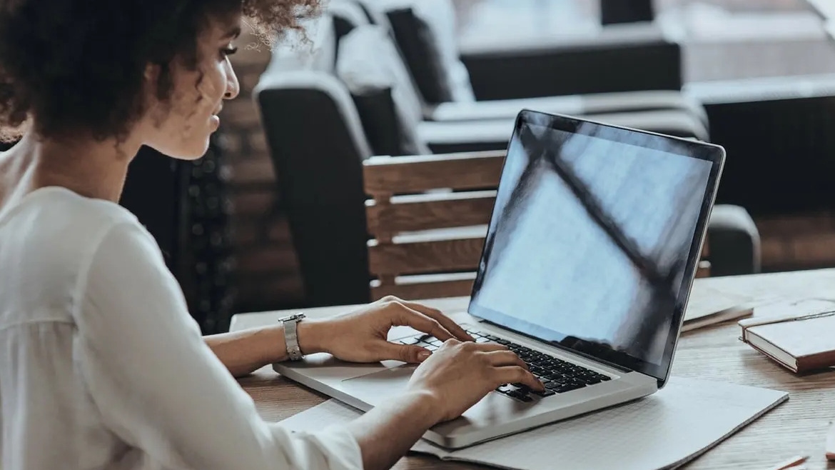 Foto di una donna al computer mentre fa delle ricerche
