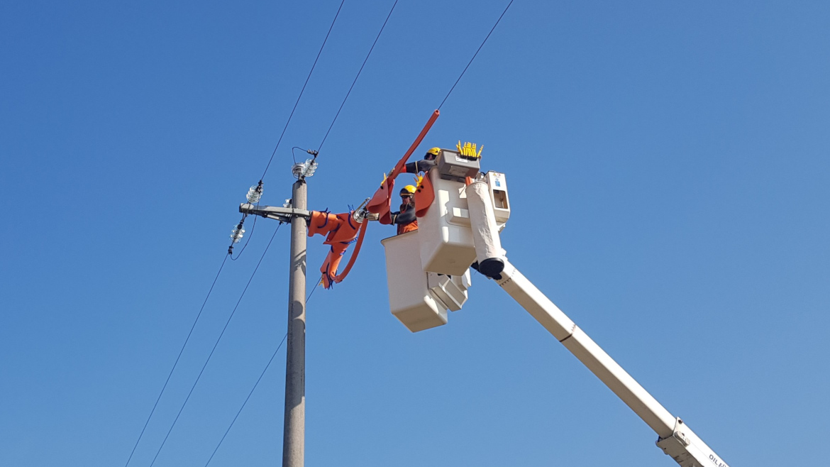 foto della squadra dei lavori sotto tensione mentre esegue un lavoro con l'autocestello