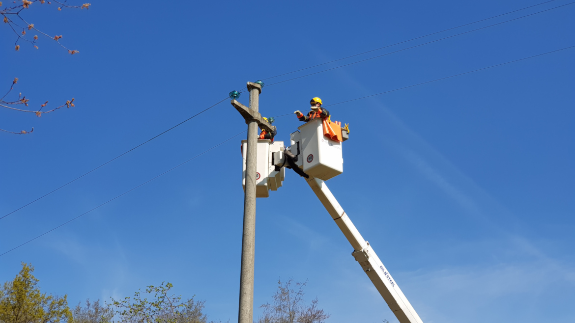 foto della squadra dei lavori sotto tensione mentre esegue un lavoro con l'autocestello