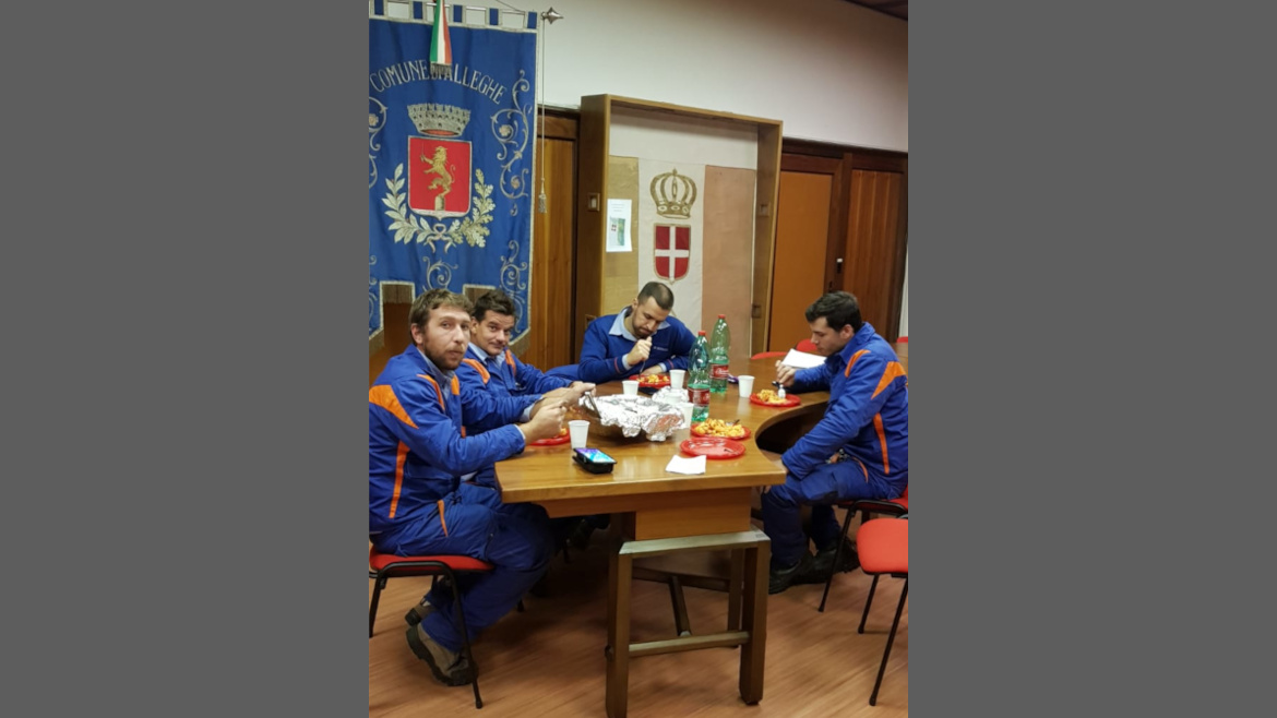 operai che stanno mangiando presso una sala municipale di alleghe