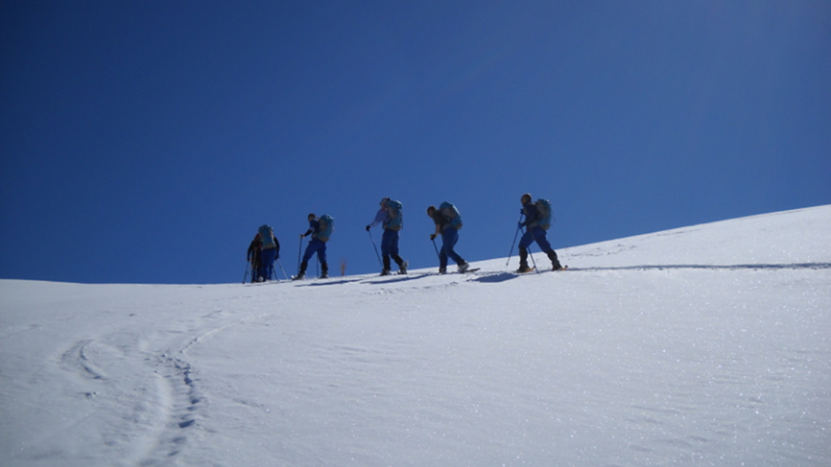Immagini di tecnici in cammino  nella neve per un intervento in montagna